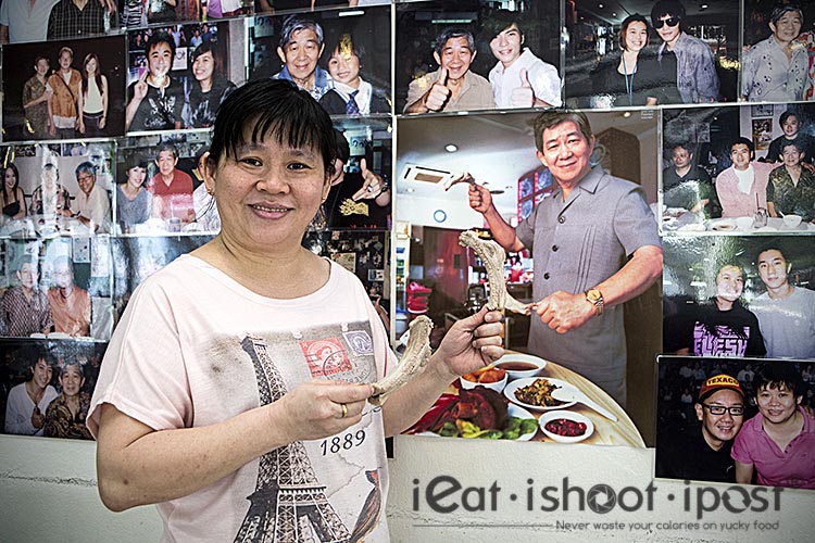 Chui Chui posing with the photo of her father in the background